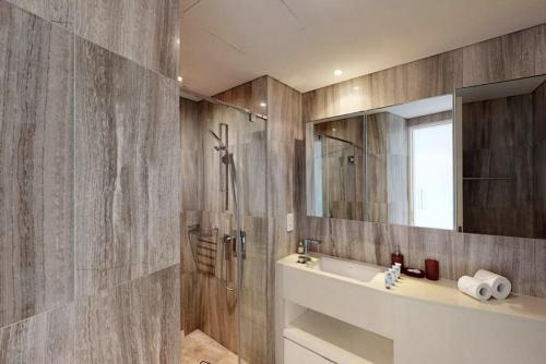 a bathroom with a shower and a sink and a mirror at Breathtaking Studio - Al Jaddaf in Dubai