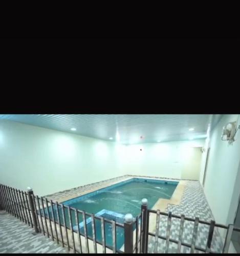 uma piscina no meio de um edifício em شاليهات هابي لاند em Ḩalaqat al ‘Afraj