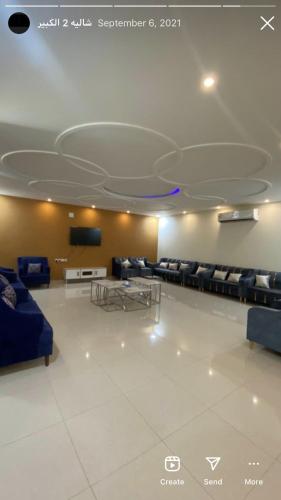 um quarto grande com sofás e uma televisão na parede em شاليهات هابي لاند em Ḩalaqat al ‘Afraj