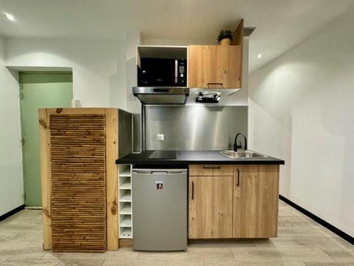 une cuisine avec un évier et un micro-ondes dans l'établissement L'escapade Toulonnaise, à Toulon