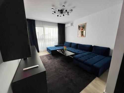 sala de estar con sofá azul y mesa en Apartament Panoramic View I Refugiu la înălțime, en Bucarest