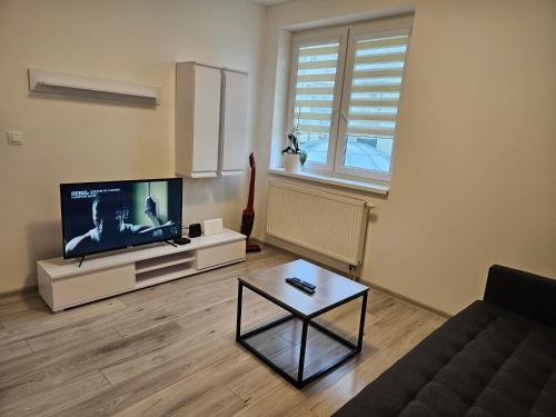 sala de estar con TV de pantalla plana y mesa de centro en Modern apartment Galaxia in the city en Galanta