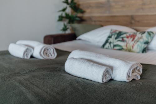 three rolled towels sitting on top of a bed at Magnifique appartement proche du centre in Crans-Montana