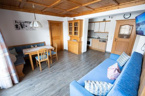 een woonkamer met een blauwe bank en een tafel bij Rohrmoser Appartements in Sankt Johann im Pongau
