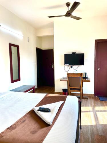 a bedroom with a bed with a remote control on it at Hotel Coffee Bean in Bengaluru