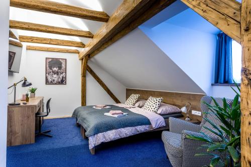 een slaapkamer op zolder met een bed en een bureau bij Restaurace Stará Lípa in Česká Lípa