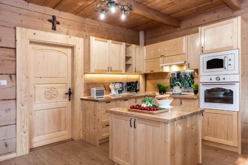 a kitchen with wooden cabinets and a white appliance at udanypobyt Dom Garden SPA in Kościelisko
