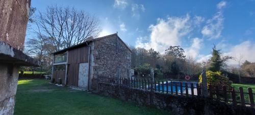 an old stone building with a fence next to it at A Casa de Suárez in Negreira