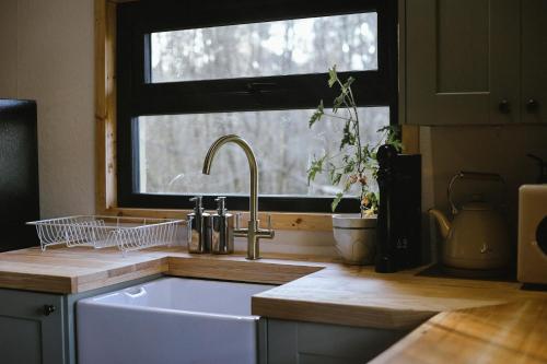encimera de cocina con fregadero y ventana en Tempo Manor Cabins, en Tempo