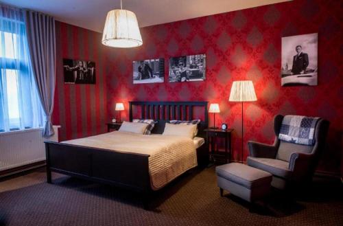 a red bedroom with a bed and a chair at Restaurace Stará Lípa in Česká Lípa