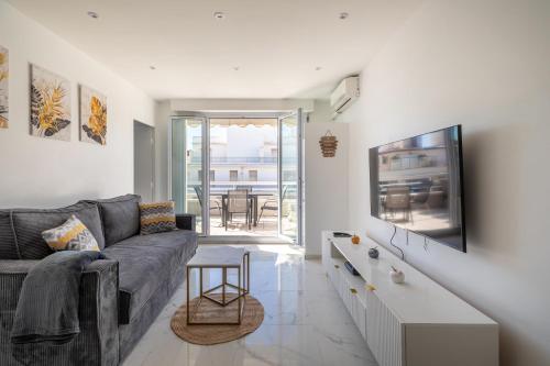 un salon avec un canapé et une télévision dans l'établissement Juan Les Pins ENTRE CIEL ET MER , dernier étage avec terrasse, à Antibes