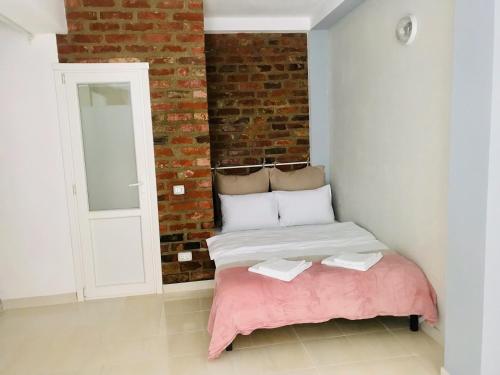 a bedroom with a bed and a brick wall at Vespasian 25 in Bucharest
