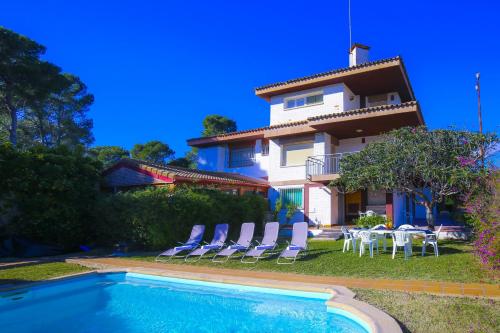 a villa with a swimming pool in front of a house at Villa Serena Planet Costa Dorada in Salou