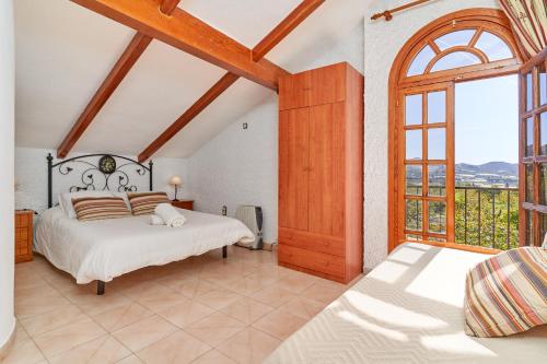 1 dormitorio con 2 camas y ventana en Finca Cabrera, en La Garnatilla