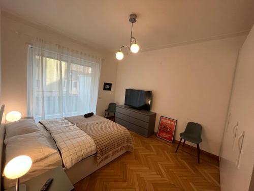 a bedroom with a bed and a flat screen tv at Festival's Home in Sanremo