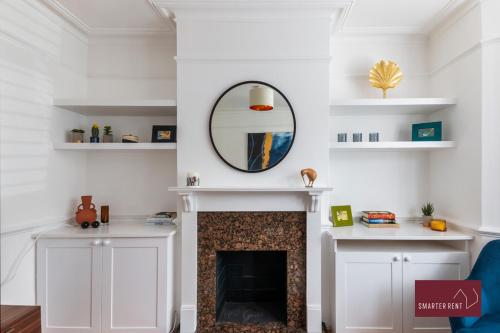 a living room with a fireplace and a mirror at Kingston On Thames Pets Welcome Garden 3Bed in Kingston upon Thames