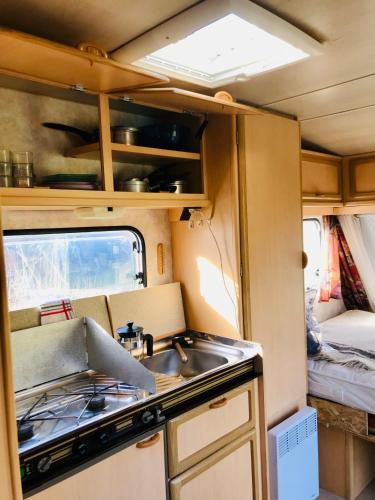 - une cuisine équipée d'un évier et d'une cuisinière dans l'établissement La caravane de la tuilerie, à Seix