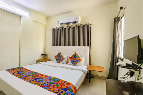 Habitación de hotel con cama y TV en FabExpress Osca Inn, en Nagpur