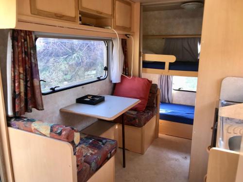 Cette petite chambre située dans une réserve comprend une table et une fenêtre. dans l'établissement La caravane de la tuilerie, à Seix