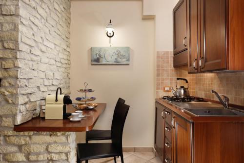 a kitchen with a table and chairs and a sink at Hotel Recostano Residence in Trevignano Romano