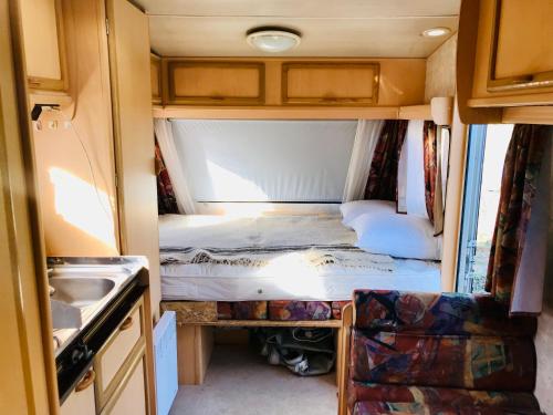 - une petite chambre dans un salon avec un lit dans l'établissement La caravane de la tuilerie, à Seix