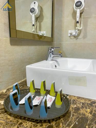 a bathroom with a sink and a tray with yellow and blue vases at Egypt Pyramids Inn in Cairo