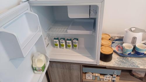 an open refrigerator filled with milk and juice at The Beach House in Valley