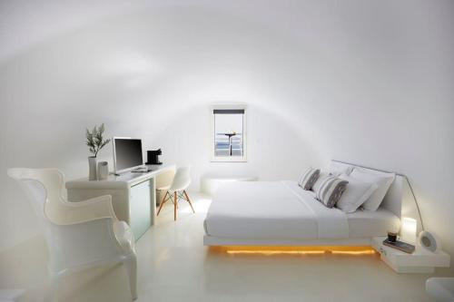 - une chambre blanche avec un lit et un bureau dans l'établissement DAY DREAM 2, à Oia