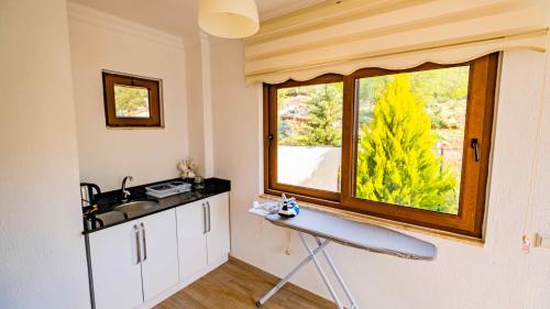 eine Küche mit einem Surfbrett auf einem Tisch vor einem Fenster in der Unterkunft VİLLA KAYA in Kaş