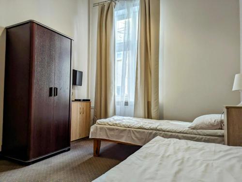 a bedroom with two beds and a large wooden cabinet at OSW Świnoujście Rybitwa in Świnoujście