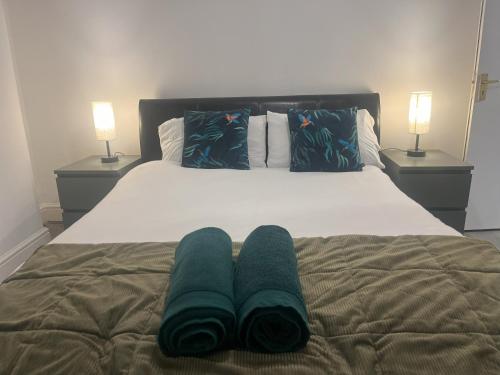 a bed with two green towels on it with two lamps at lovely place near to beach in Brighton & Hove