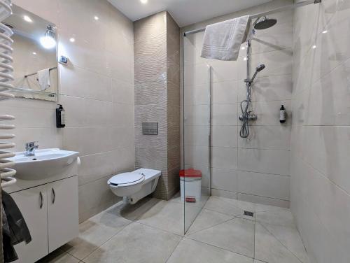 a bathroom with a shower and a toilet and a sink at OSW Świnoujście Rybitwa in Świnoujście