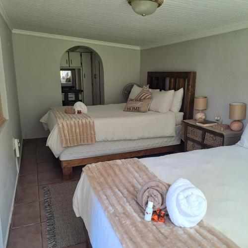 a bedroom with two beds and a mirror at Rosies Inn in Piet Retief