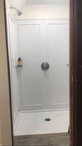 a shower with a glass door in a bathroom at room with a private shower in Arlington