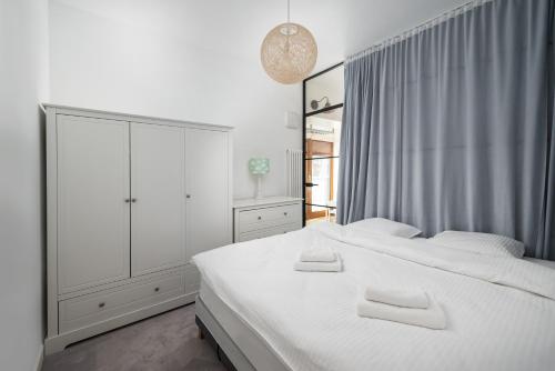 1 dormitorio blanco con 2 camas y ventana en Sky Garden Premium Penthouse, en Varsovia