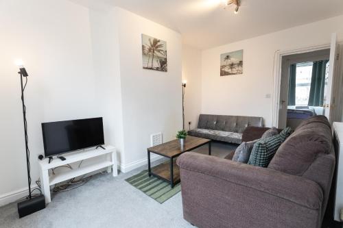 a living room with a couch and a tv at April Disc - Long Stay - Contractors in Bristol