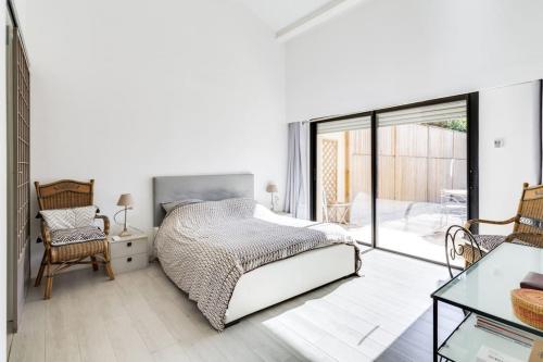 une chambre blanche avec un lit et un balcon dans l'établissement Villa Recampado, à Cassis