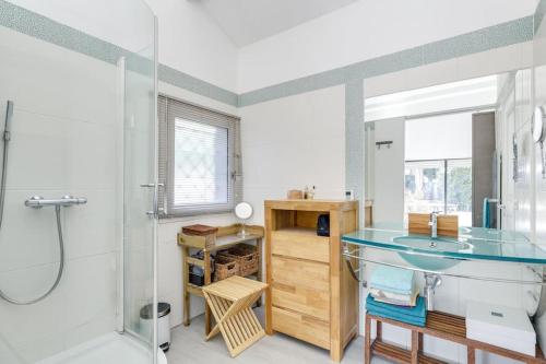 La salle de bains est pourvue d'un lavabo en verre et d'une douche. dans l'établissement Villa Recampado, à Cassis