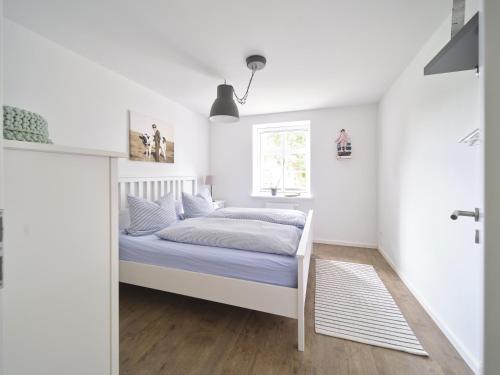 a bedroom with a bed and a window at Hof Maiholm - Sattelkammer in Medelby