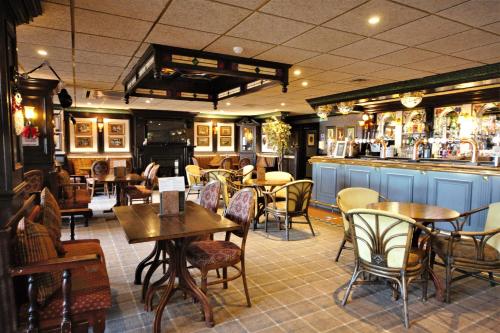a restaurant with tables and chairs and a bar at Highfield Hotel in Houghton le Spring