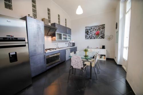 cocina con mesa, sillas y nevera en Appartamento Casa Nizza - Metro Lingotto fiere by Bib's Apartments, en Turín