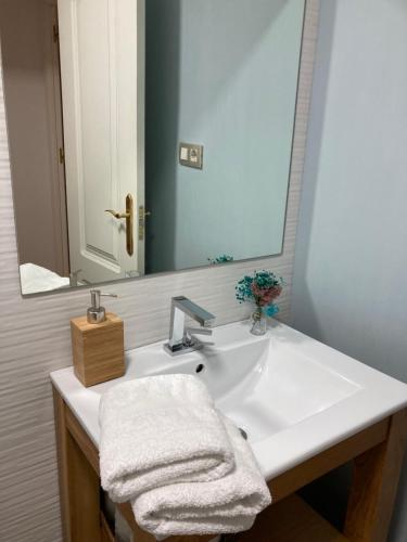 ein Badezimmer mit einem weißen Waschbecken und einem Spiegel in der Unterkunft Apartamento Enriqueta in Granada