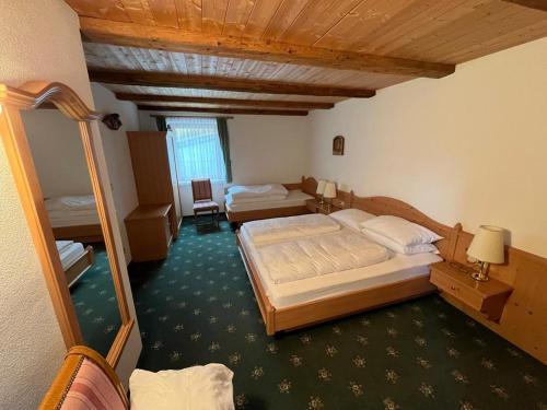 Habitación de hotel con 2 camas y espejo en Lenzerhof en Lappago