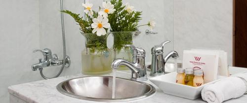 a bathroom sink with a vase with flowers in it at Hotel Península Valdés in Puerto Madryn