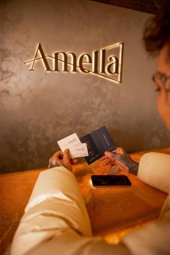 a man is sitting at a table with a book at Aparthotel Amella in Rīga