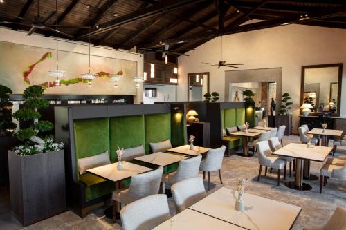 a restaurant with tables and chairs in a room at Terre Blanche Hotel Spa Golf Resort in Tourrettes