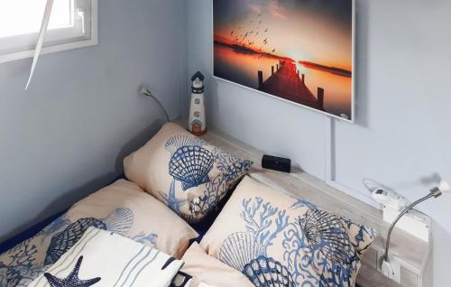 a room with a bed with pillows and a picture on the wall at 1 Bedroom Beach Front Ship In Havelsee Ot Ktzkow 