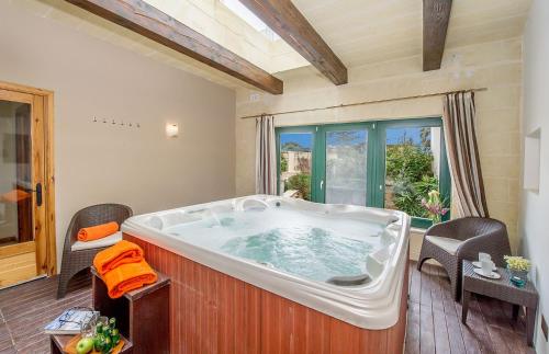 a large bath tub in a room with a window at Veduta Holiday Home in Qala