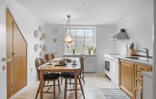 a kitchen with a table and chairs and a window at 3 Bedroom Lovely Apartment In Engesvang in Engesvang