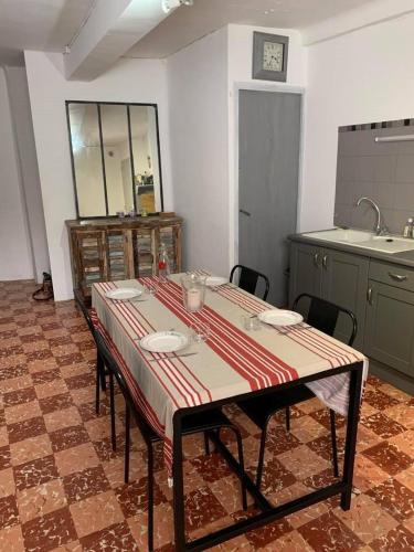 - une cuisine avec une table, des chaises et un évier dans l'établissement 5RBUT1 - Maison familiale sur deux niveaux en plein coeur du centre ville, à Collioure